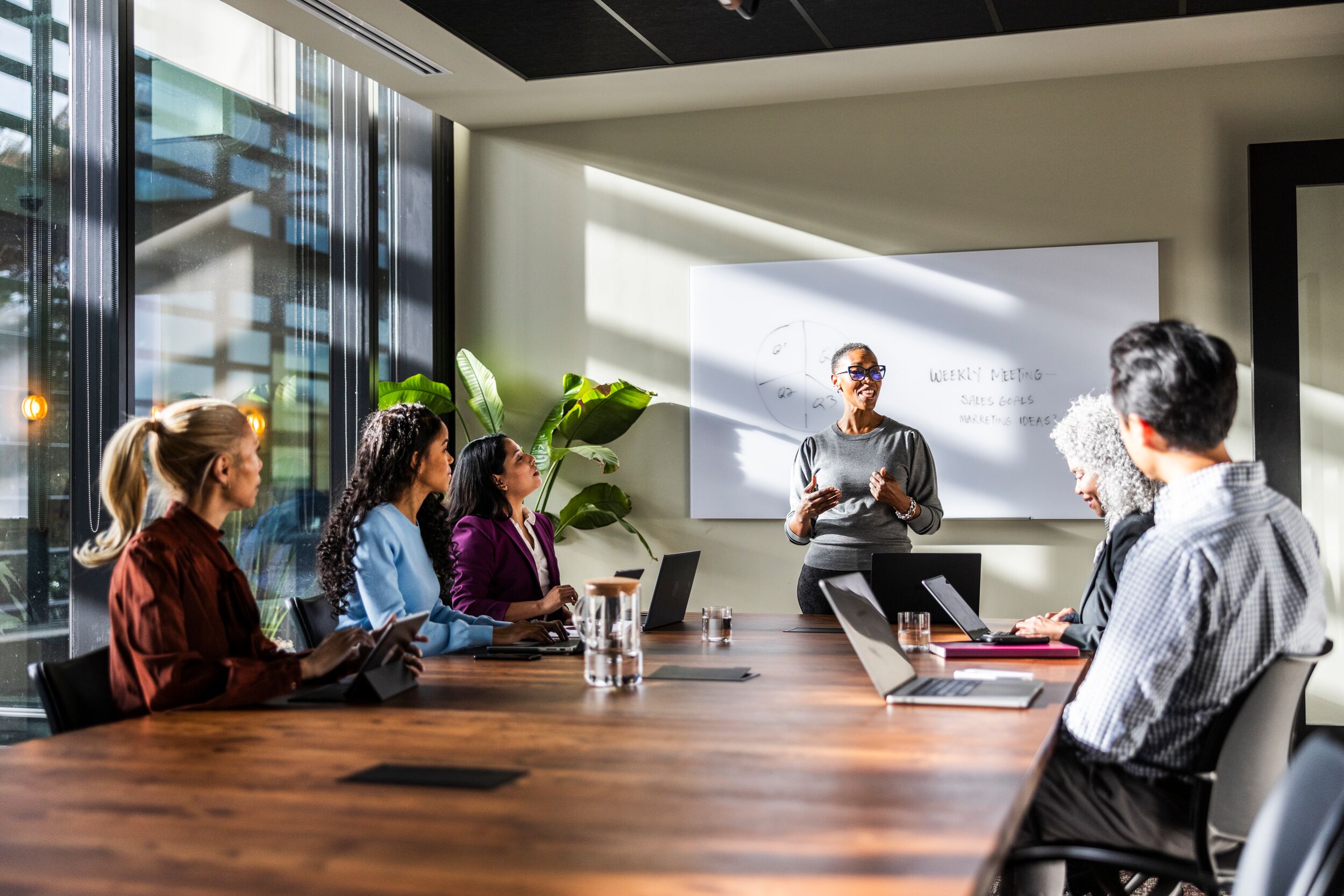 Woman leading a meeting at conference table.