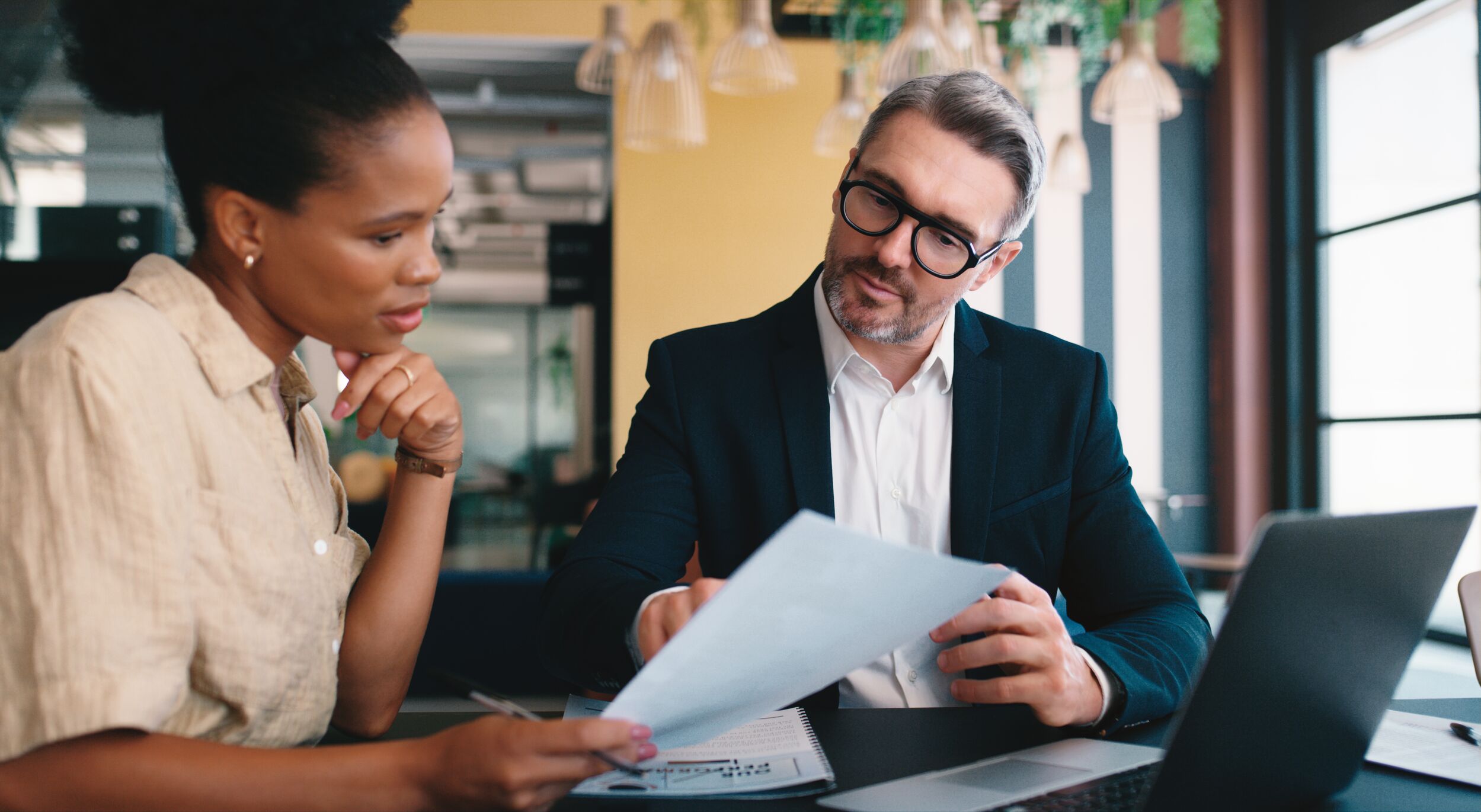 Male advisor and female client going over paperwork.