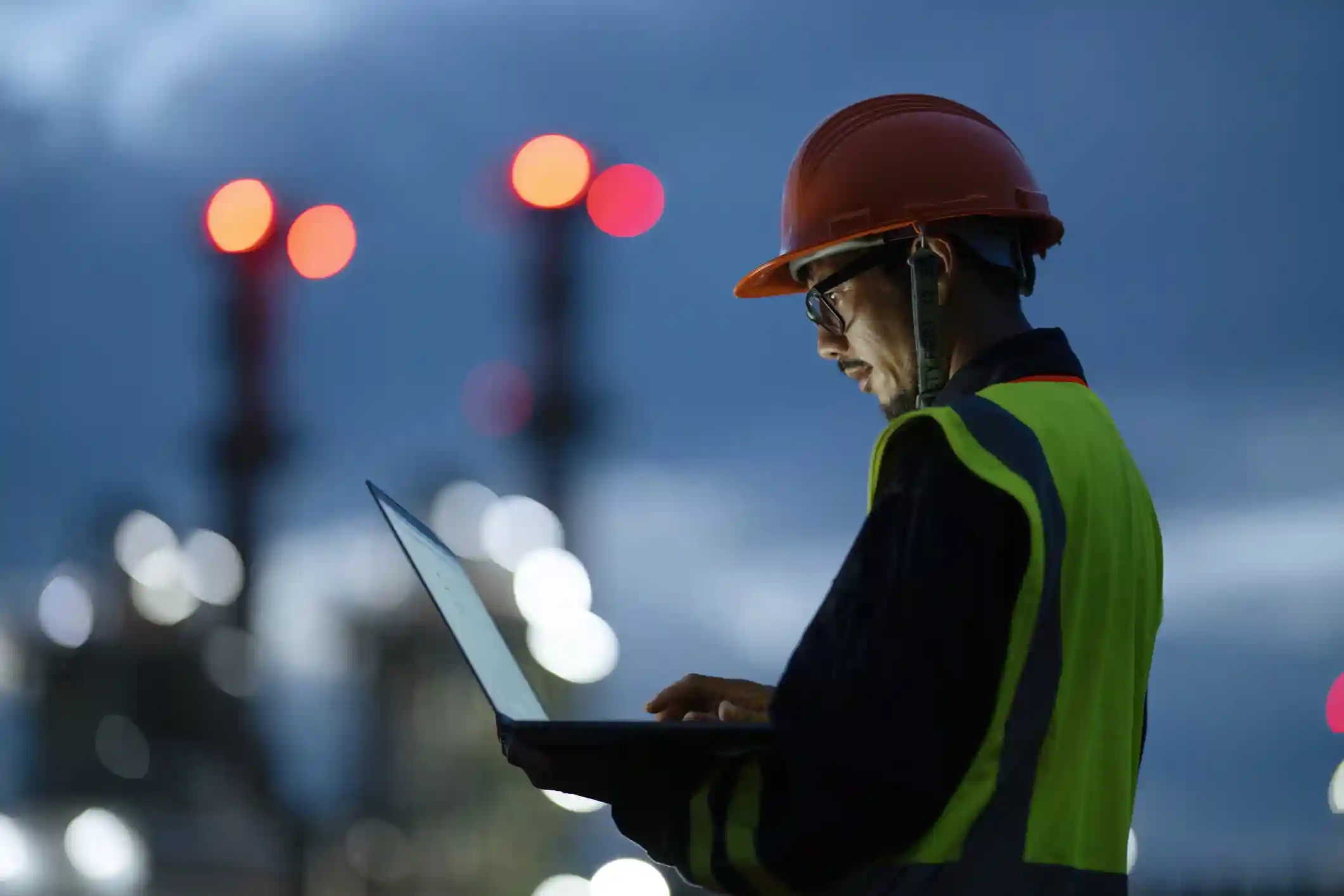 Construction worker looking at a laptop in the early morning.