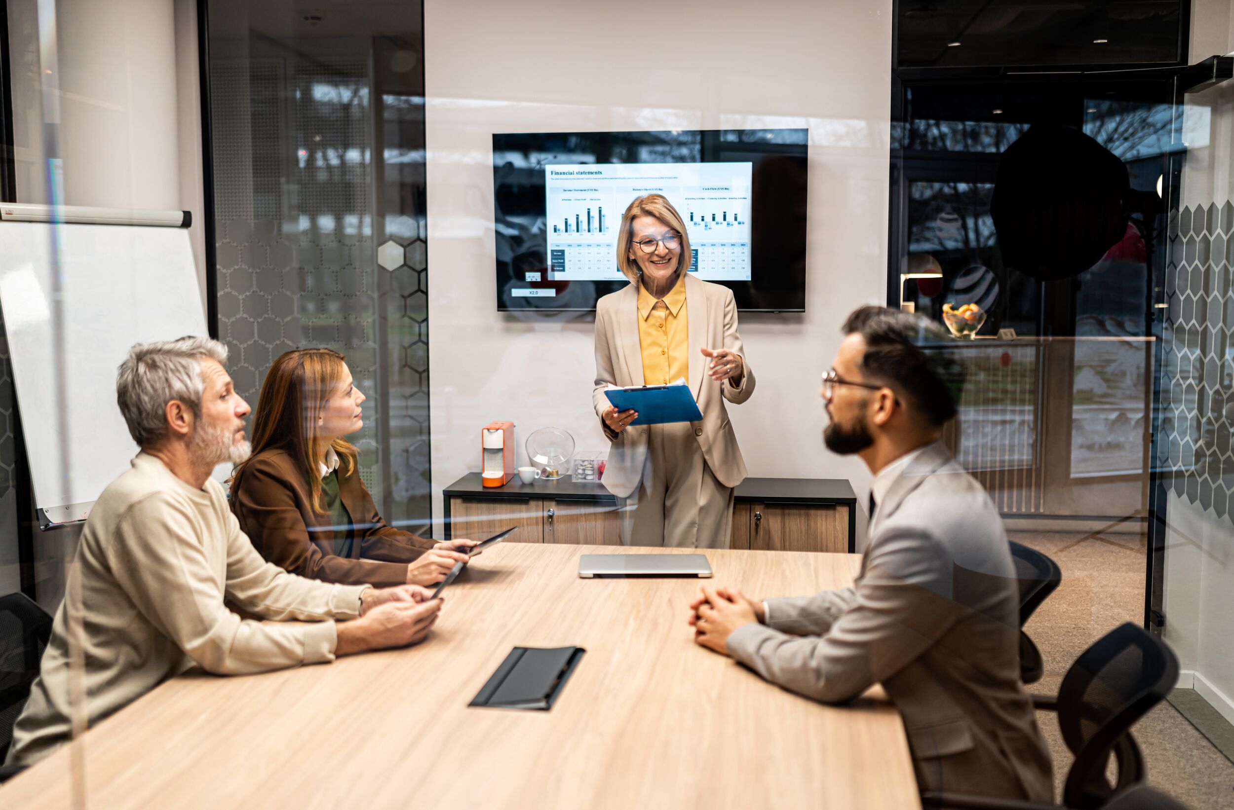 Mature adult business woman presenting data during meeting.