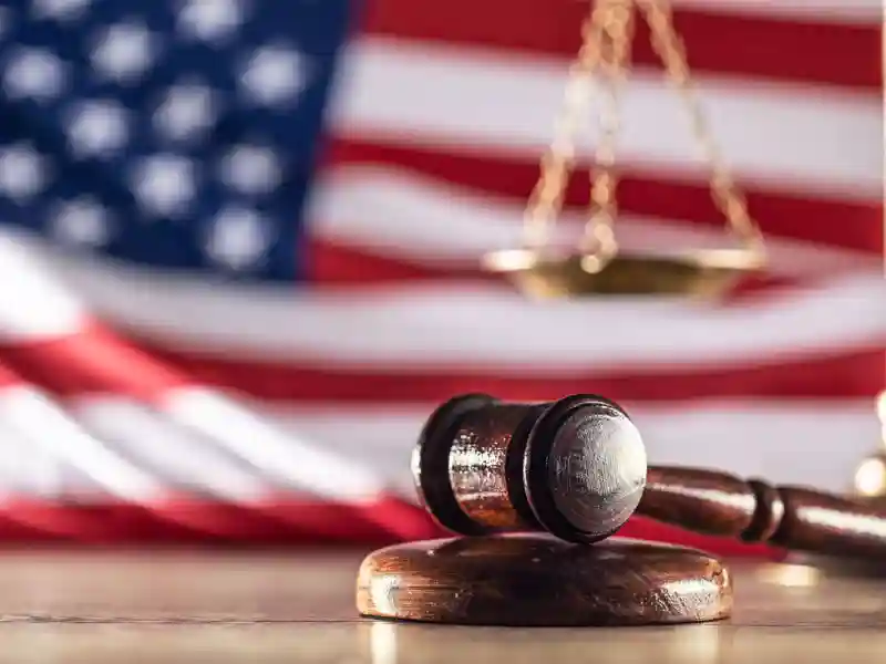 Gavel and scales with a US flag in the background as symbols of a jurisdiction.