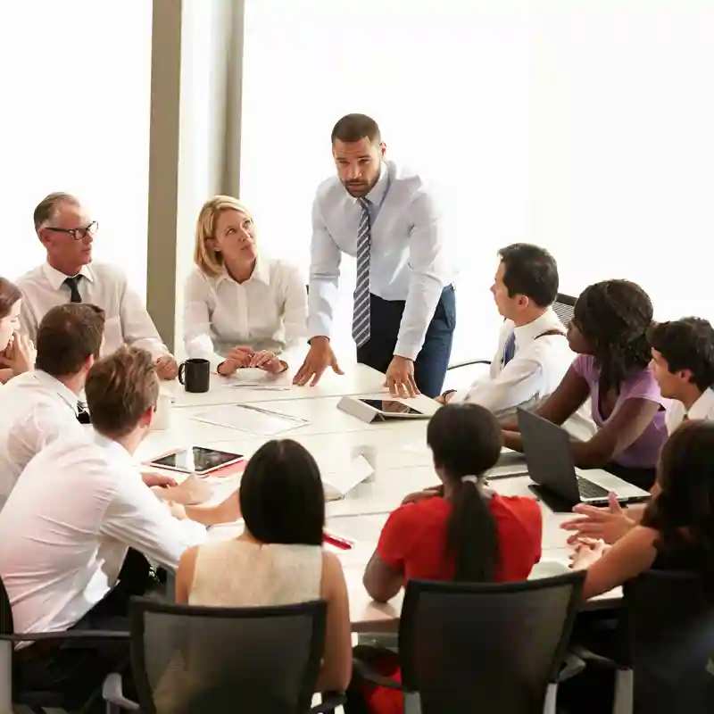 Businessman addressing meeting around boardroom table
