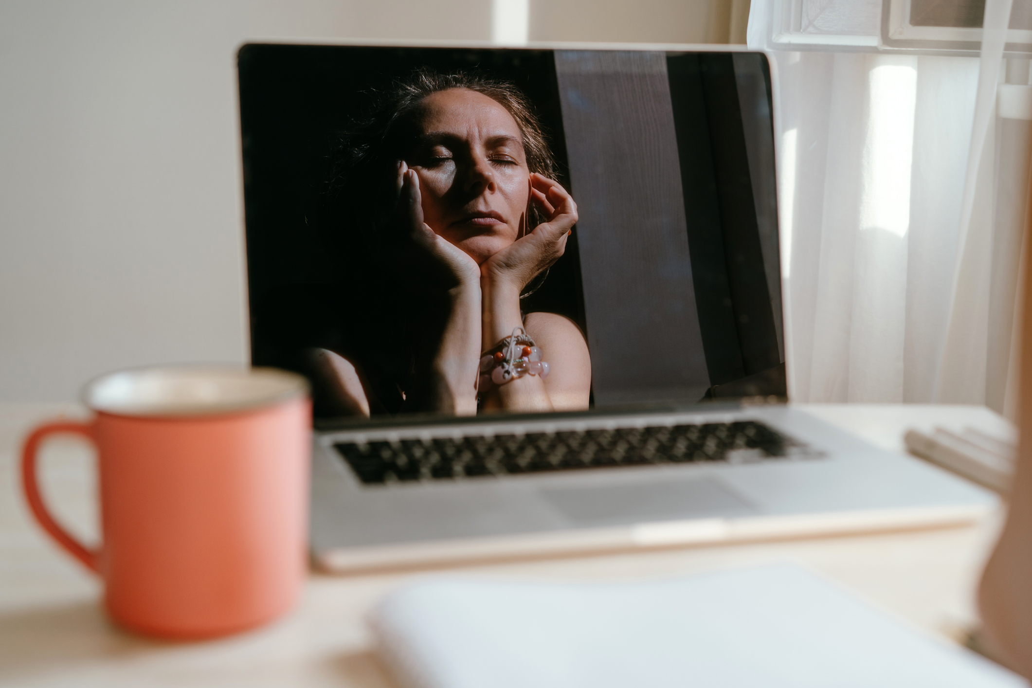 Exhausted woman sits at the computer massaging her temples. 
