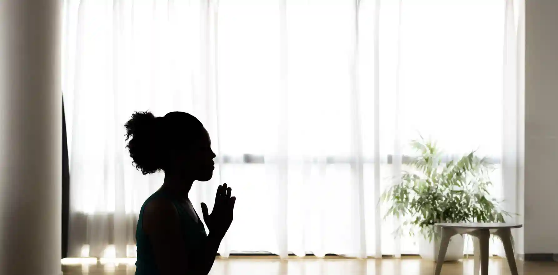 Silhouette of woman with clasped hands