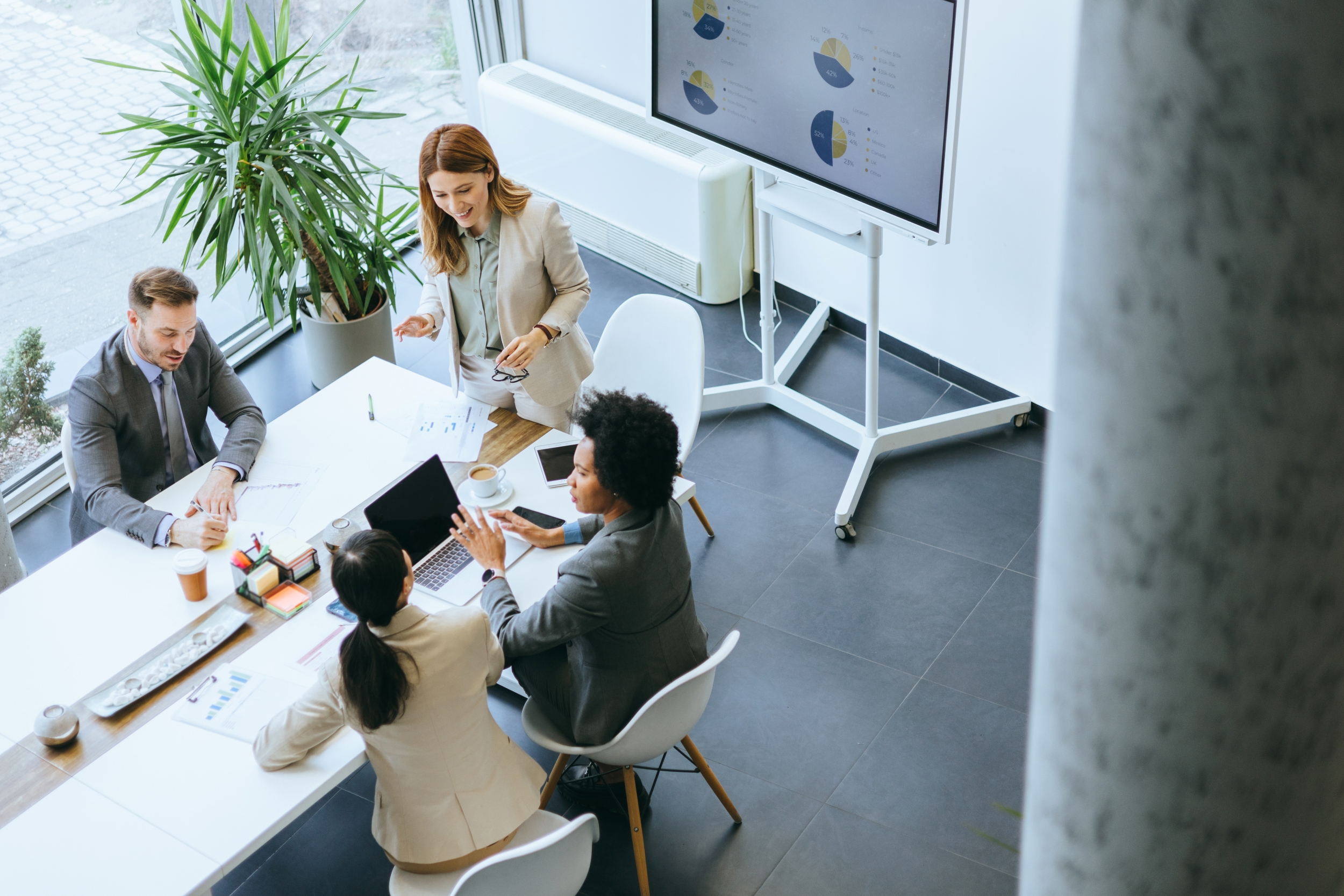 Four coworkers having a friendly business meeting in a modern office.