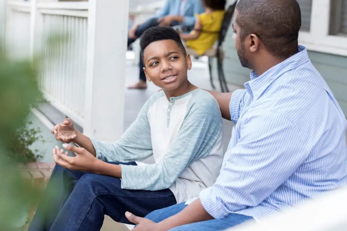 Father talking to his son with his arm on his shoulder