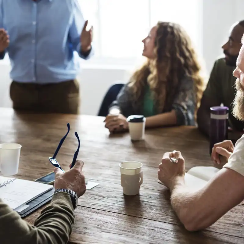 Coworkers sitting at a table listening to a presentation