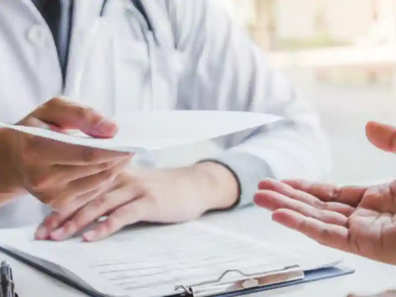 A medical professional gives a patient a new prescription.