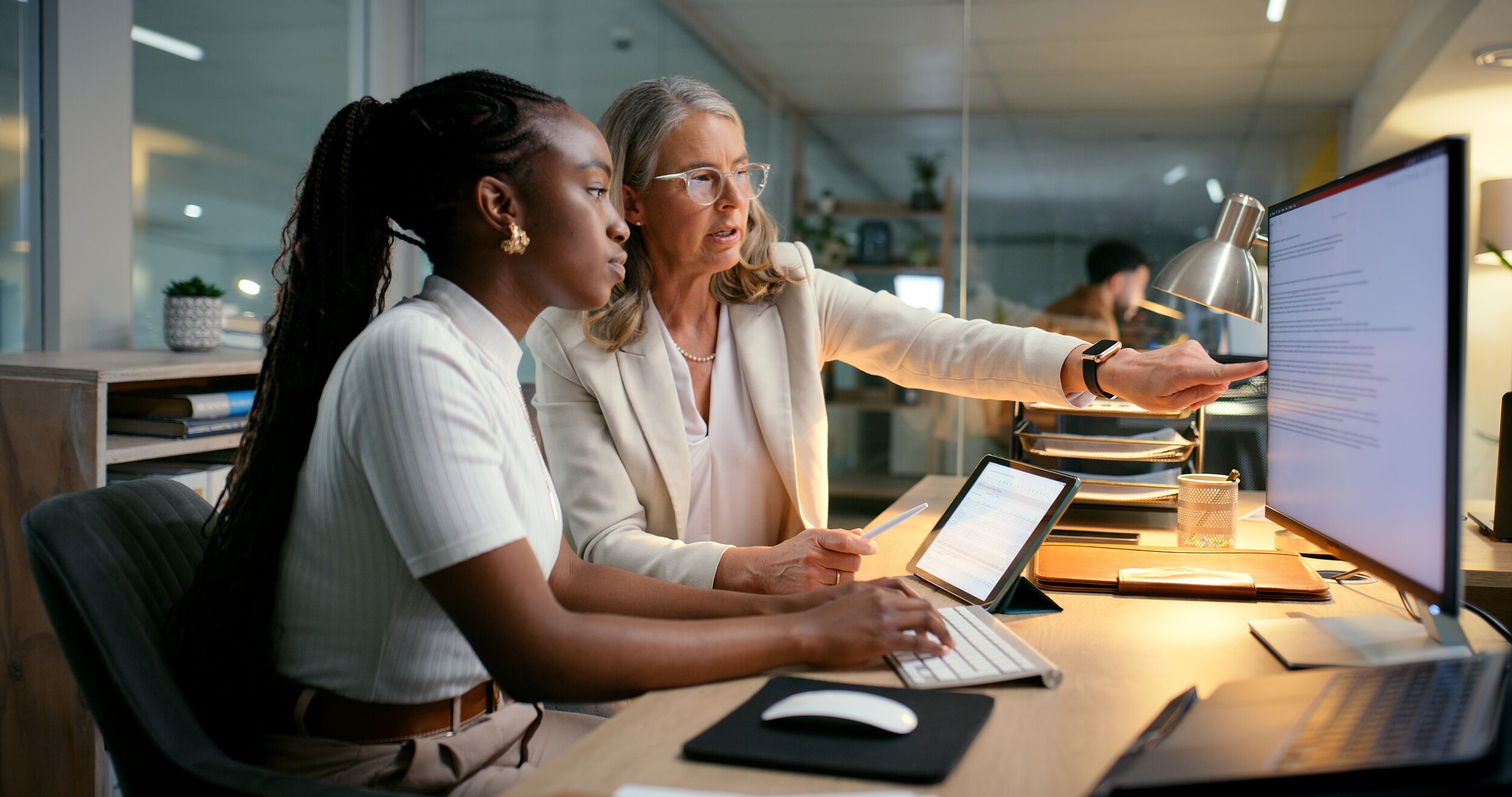 Two women reviewing information on a computer screen.