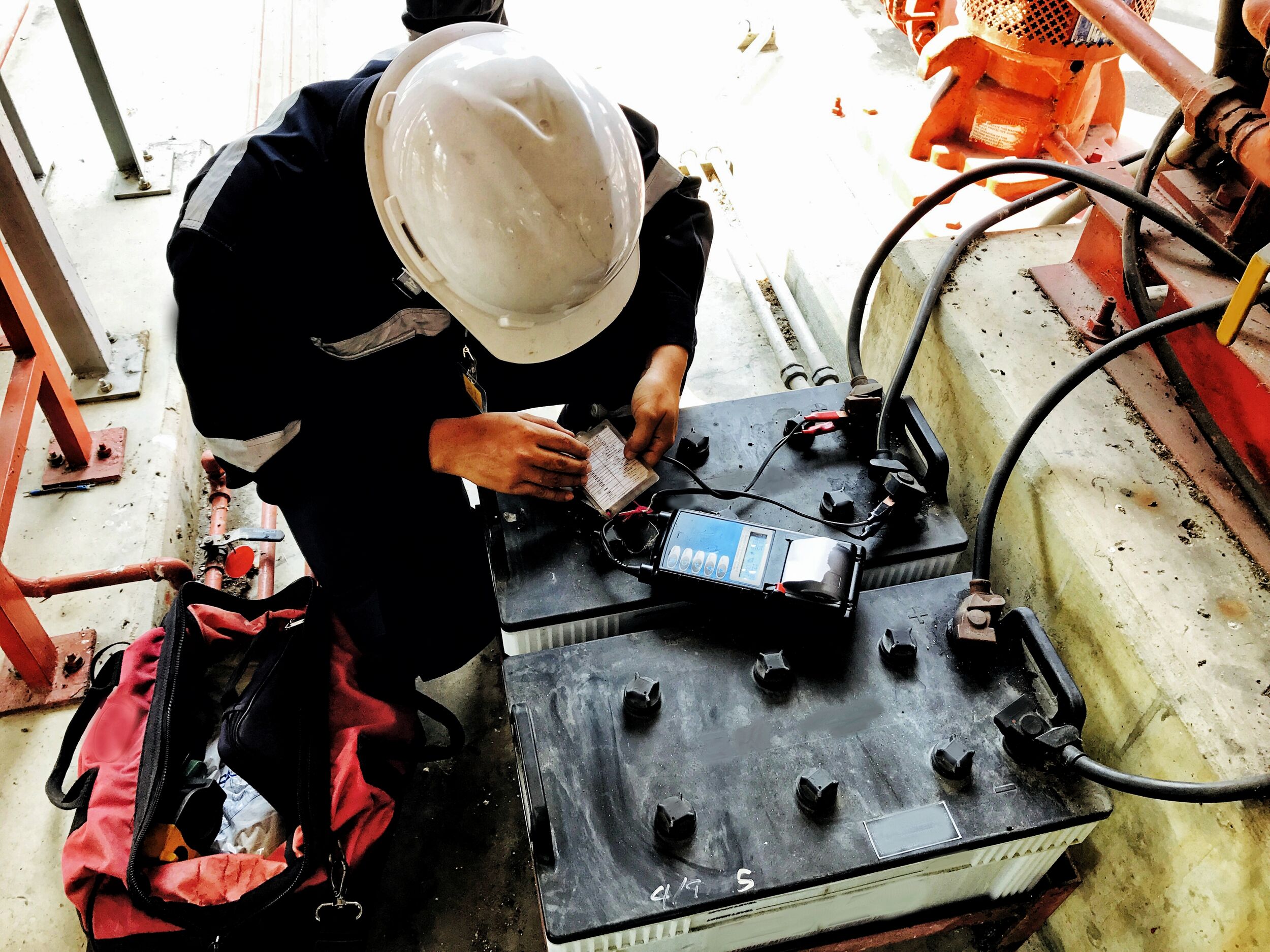A technician checking the condition of a battery using a battery tester.