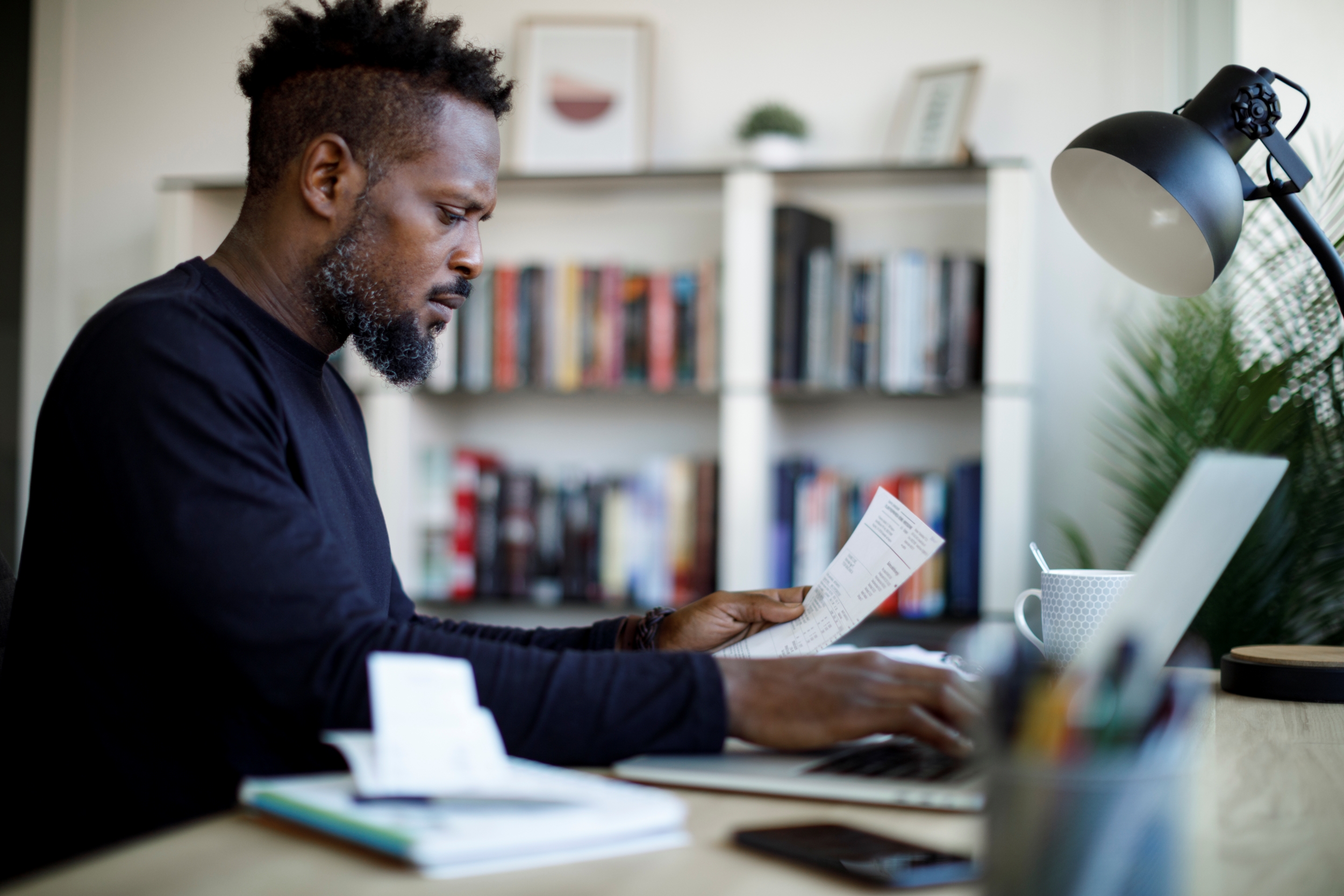 Man sitting at a desk working on his laptop.