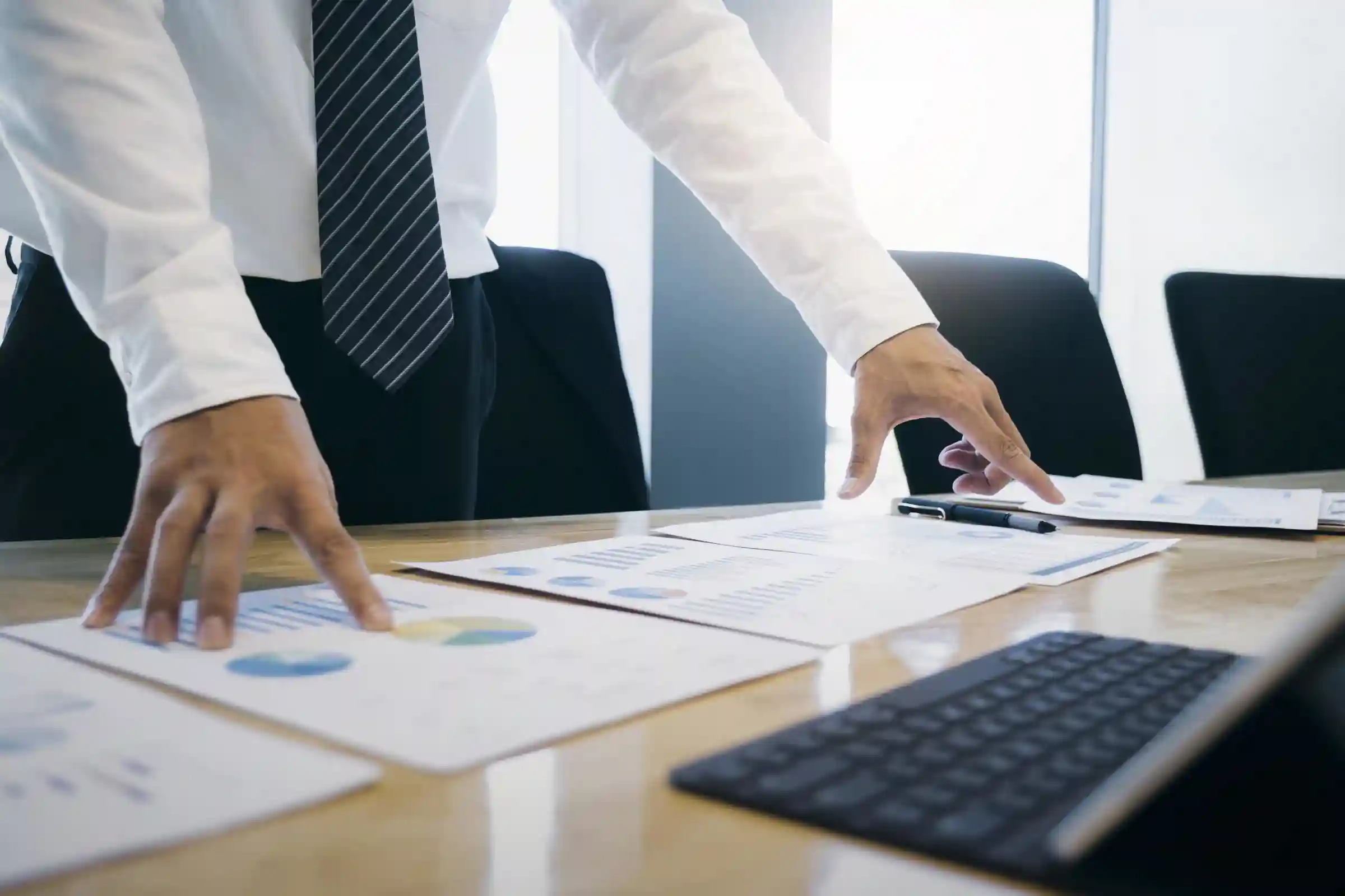 Businessman standing at a desk looking at paperwork.