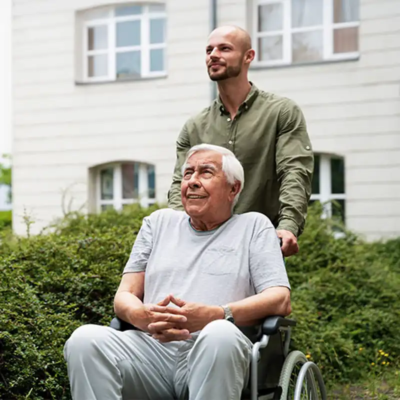 A son acts as caregiver to his wheelchair-bound father.