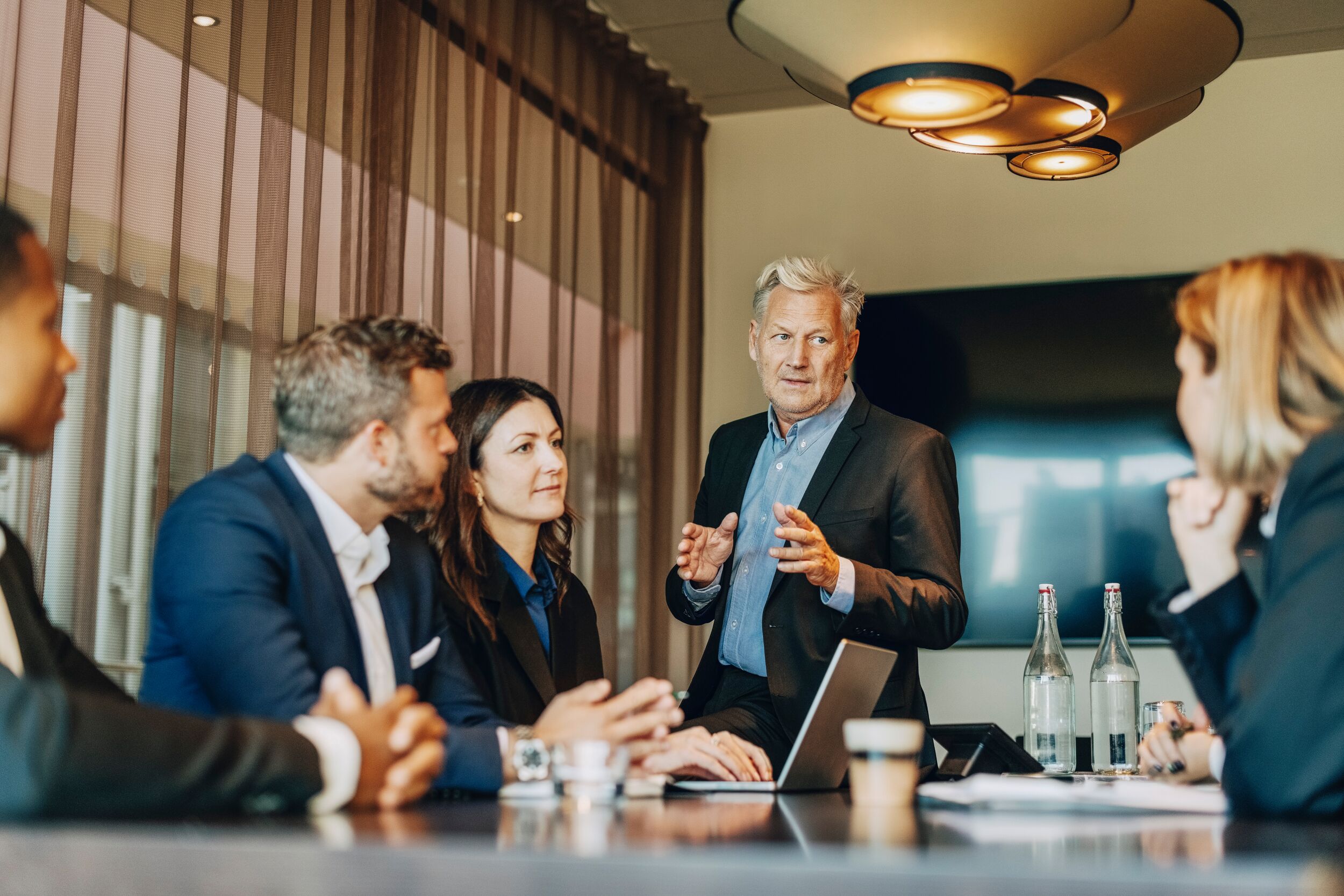 Man in a suit leading a business meeting.