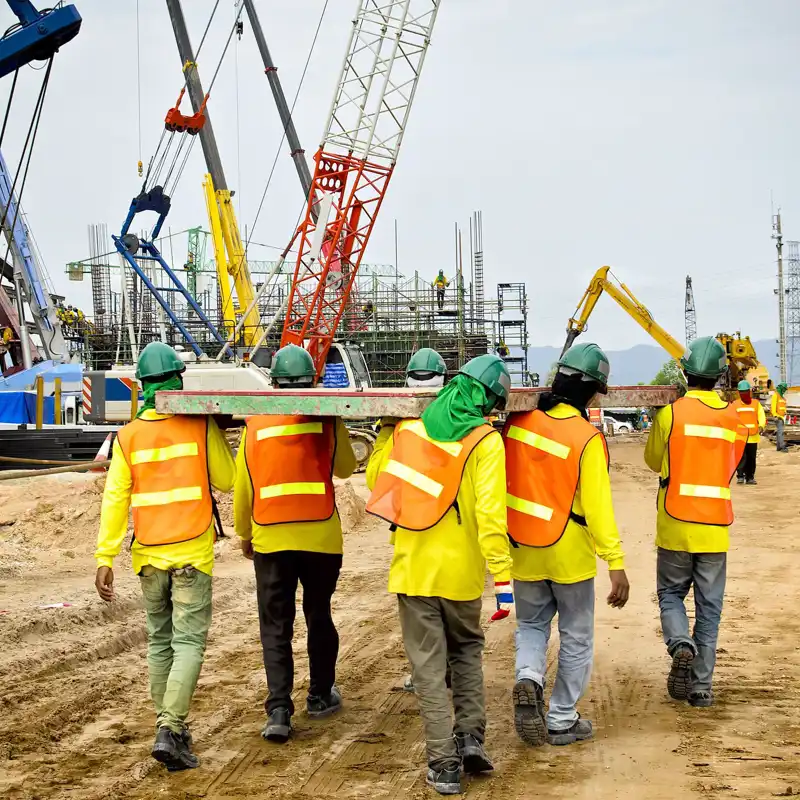 Construction workers carrying wood.