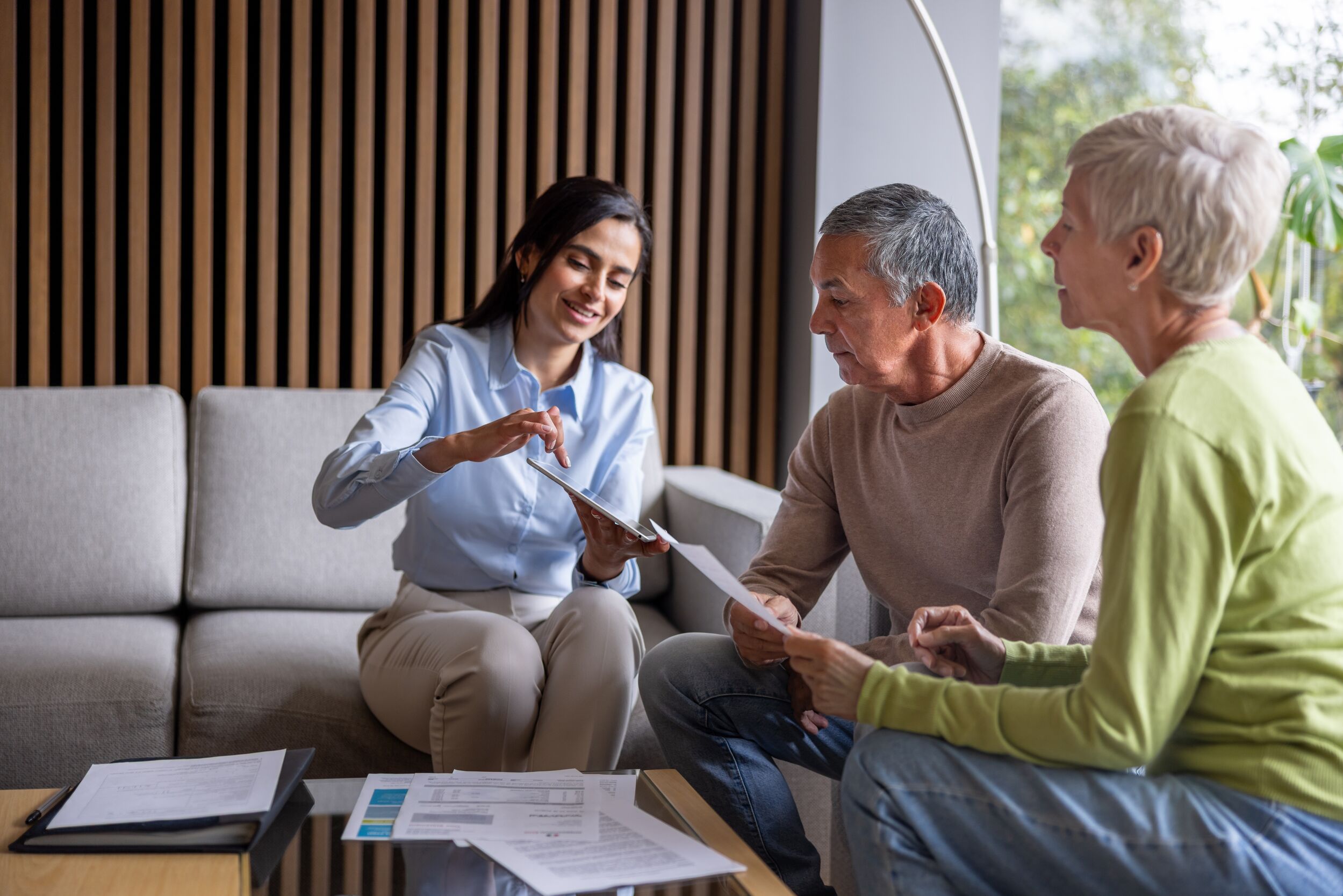 Real estate agent talking to a mature couple buying a house.