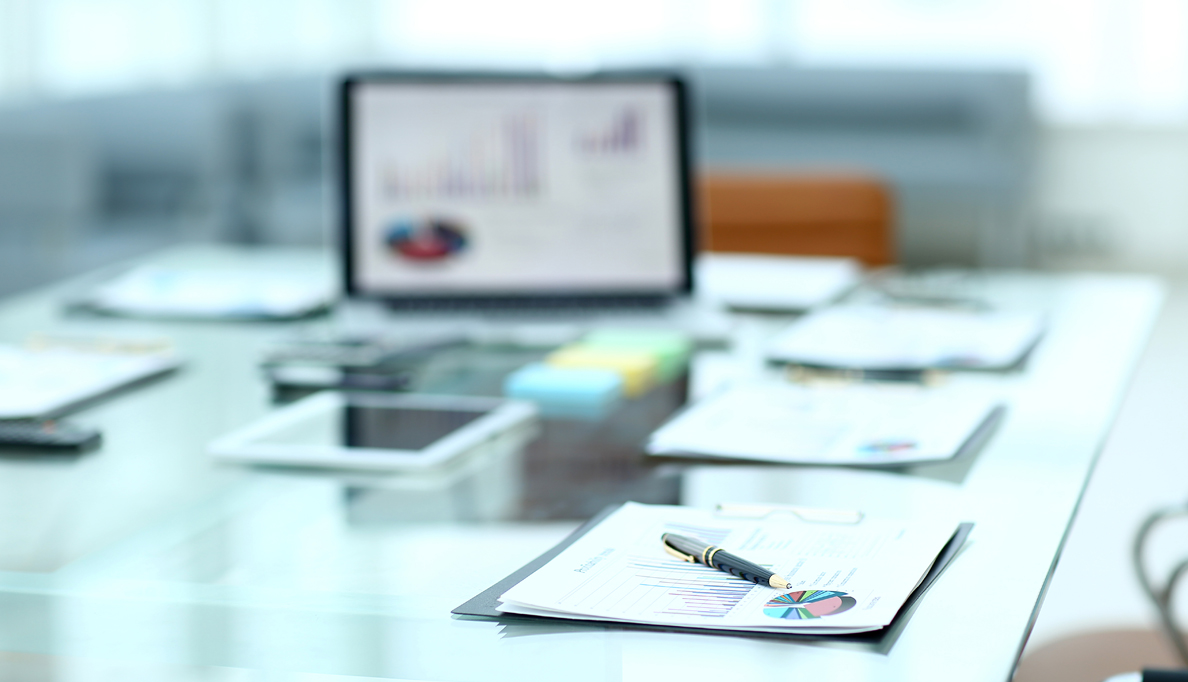 Reports with pie chart placed on conference table.
