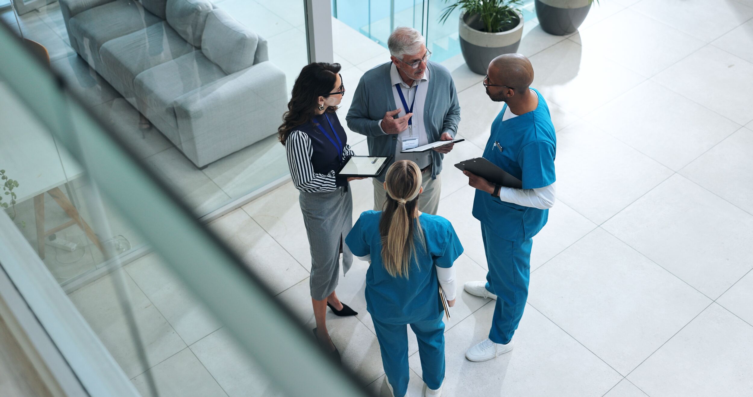 Doctors, medical team and tablet with discussion, advice and above for surgery or patient records.