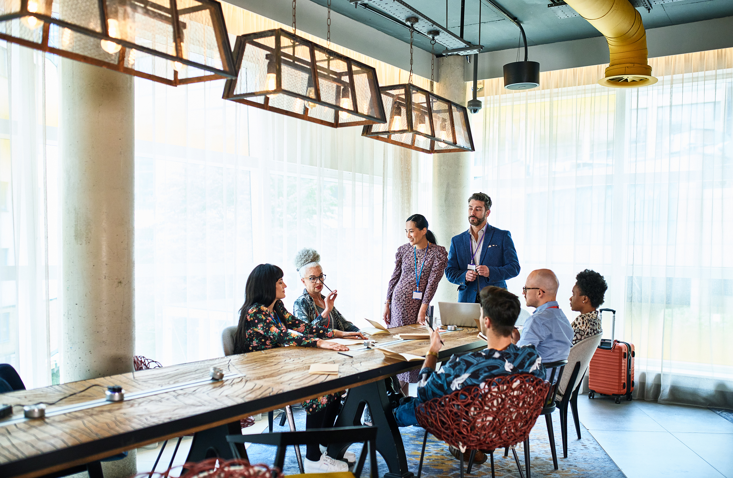 Group of people sitting or standing at a large table.