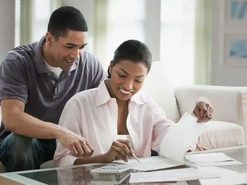 a young couple sitting at their coffee table going over paperwork